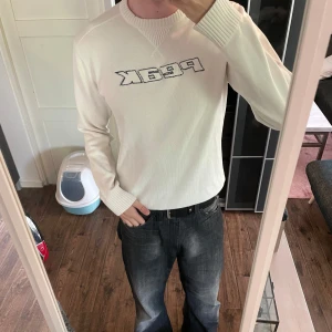 Vit stickad tröja  Peak Performance - Vit stickad vintage tröja från Peak Performance med broderad logga i blått på bröstet. Tröjan har rund halsringning, ribbade muddar och lång ärm. Tröjan är i väldigt bra skick och passar storlek M. Skriv om du har några frågor 🙏😊