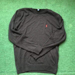 Svart långärmad tröja - En stilren svart långärmad tröja med rund hals och ribbade muddar. Perfekt för dig som gillar en clean och enkel look. Tröjan är i mjukt material och passar till det mesta. Snygg att matcha med jeans eller joggers.