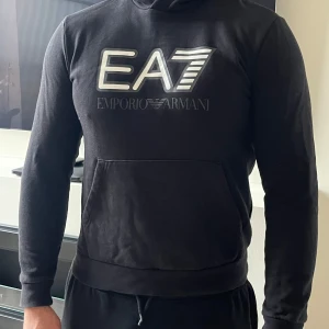 Svart EA7 Emporio Armani hoodie - Svart hoodie från EA7 Emporio Armani med stor logga framtil. Äkta