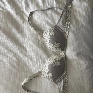 Grå spets-bh från Intimissimi - Superfin grå bh från Intimissimi med vita spetsdetaljer och vadderade kupor. Bh:n har justerbara axelband och fin spets längs kanterna för en extra snygg look. 