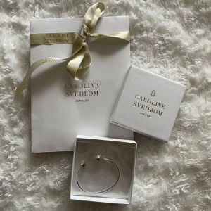 Caroline Svedbom armband - Superfint armband i silver färg från Caroline Svedbom. Helt nytt och oanvänt, fortfarande plomberat. Bandet är justerbart så passar de flesta handlederna. Medföljer ask och fin presentpåse. 🌸💕