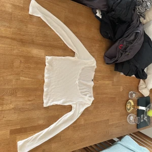 Vit ribbad långärmad topp med spets - Vit topp med spets från h&m divided i storlek M. Använt många gånger men inte nå hål men det finns en liten fläck på ena ärmen längst ut, ska tvätta den och om du är intresserad kan jag säga om fläcken går bort. :)