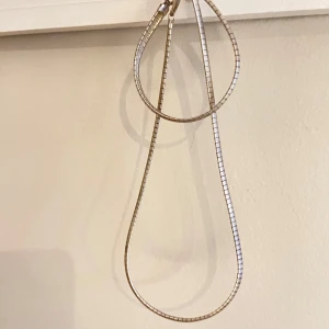 Stora silverfärgade örhängen - Säljer ett par stora örhängen i silverfärg med en modern, droppformad design. De har en slät, glansig yta och är tillverkade av metall. Perfekta för dig som gillar statement-smycken och vill sticka ut lite extra.