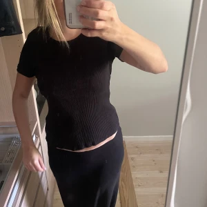 Svart ribbad T-shirt från Lindex - Ja säljer en basic svart ribbad T-shirt.Sitter tight.Pris går att diskutera 