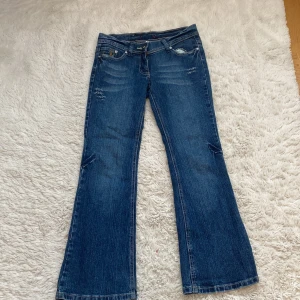 Blå bootcut jeans med fina detaljer  - Säljer dessa blå bootcut low waist jeans! Jeansen har massa fina detaljer. Märket heter george🥰
