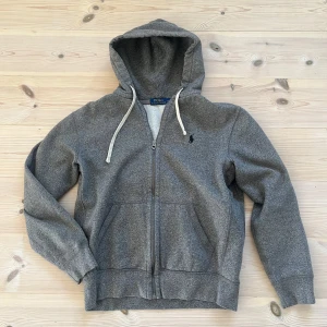 Polo Ralph Lauren Zip-up Hoodie - En Polo Ralph Lauren Zip-up hoodie i mycket bra skick utan fläckar eller skador. Tröjan är i storlek M.