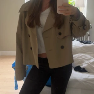 Kort beige trenchcoat med stora knappar - Snygg trenchcoat i beige. Osäker på om jag vill sälja så säljer endast vid bra pris. Storlek L men passar mig perfekt som vanligtvis när xs/s! 
