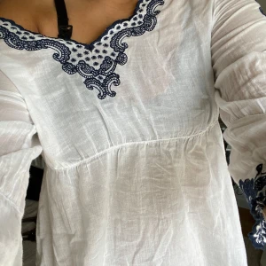 Vit blus med blå broderi från Culture - Supersöt vit blus från Culture med mörkblå broderade detaljer längs v-ringningen och ärmsluten. Lätt och luftig i bomull, perfekt för varmare dagar. Långärmad modell. Endast använd ett fåtal gånger❤️🌊