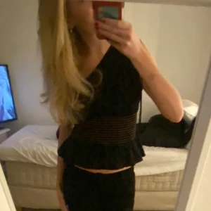 Svart one shoulder topp med volang - Säljer en svart one shoulder topp med volangkant nertill och smala guldiga/oranga ränder runt midjan 😍 Perfekt för dig som vill ha något unikt och trendigt 🥰 Tröjan är från Zara i storlek M men jag skulle säga att den är lite i storlek 💞Skriv vid frågor eller prisförslag 💗