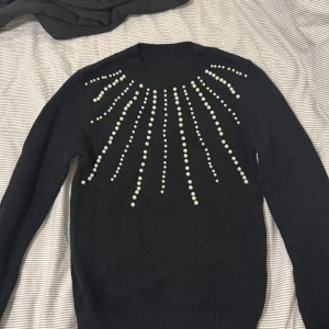 Svart stickad tröja med pärlor  - Säljer en snygg stickad tröja med pärlor, jätte fin passform, perfekt till vinter!