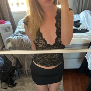 Svart spetstopp - Svart spetstopp med öppen rygg som man föster i bak med en liten hake. Sååååå vacker