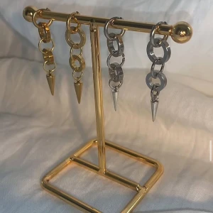 Chunky örhängen med kedjor och spikes - Säljer coola chunky örhängen med kedjelänkar och spetsiga spikes. Finns i både guld och silver, perfekta för att ge din look en edgy vibe. Passar dig som gillar statement-smycken och vill sticka ut.