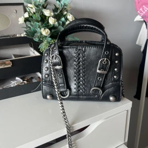 Snygg liten svart väska med nitar  - Supersnygg liten handväska med nitar. I fint skick. Kedjan är silver samt alla detaljer på väskan.