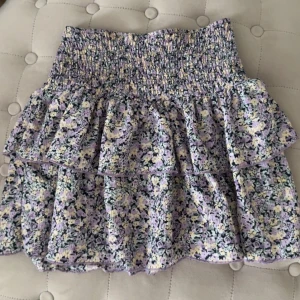 Minikjol med volanger  - Minikjol med volanger och blommönster från Gina Tricot i storlek xxs men passar även xs💕 använt ett få antal gånger💕