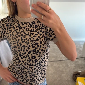 Beige leopardmönstrad topp - Säljer en snygg beige topp med leopardmönster. Toppen har korta ärmar och rund halsringning💓✌🏻