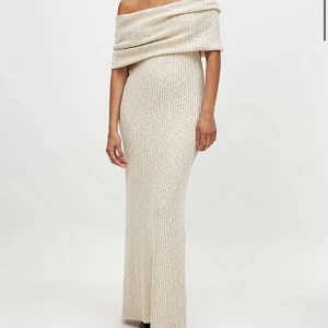 Beige ribbad offshoulder klänning - Elegant beige långklänning med ribbad struktur och offshoulder-design. Perfekt för en stilren look. Slut online och helt oanvänd