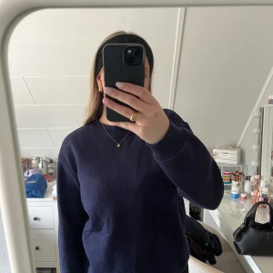 Mörkblå sweatshirt - Säljer en stilren mörkblå sweatshirt med rund hals och långa ärmar. Är väl använd 