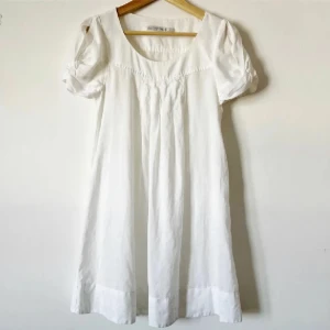 Vit klänning  - Charmig vit linneklänning från Zara med korta puffärmar och rund halsringning, säljer pga den är för liten. Använd ett fåtal gånger så i bra skick. Storlek XS. Använd gärna KÖP NU om du vill köpa.