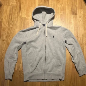 Grå hoodie från Ralph Lauren - Säljer en stilren ljus grå hoodie från Ralph Lauren!⭐️   Den är i mycket bra skick och har en rutigt mönster på luvan! Nypriset på denna tröja är 2500‼️mitt pris 999✅. Om ni har några frågor så tveka att inte höra av er!😁 priset är ej hugget i sten och jag går ner vid snabb affär eller köp av flera plagg från min profil!🔥🙌Säljer igen för att den inte passade😀