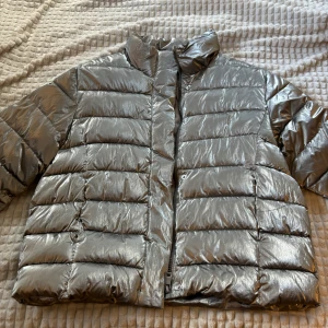 Silverfärgad pufferjacka - Snygg och glansig silverfärgad pufferjacka  från Zara. Strl 13-14 år men passar mig som vanligen har dam S. Endast använd ett fåtal gånger och säljes pga att den inte kommer till användning längre