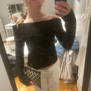 Svart offshoulder tröja - Säljer en stilren svart offshoulder tröja med långa ärmar. Perfekt för en trendig look. Passar bra till både jeans och kjol.