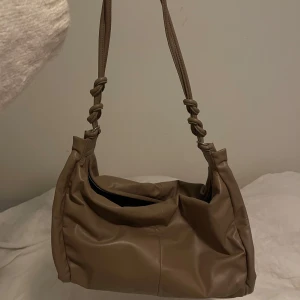 Axelremsväska i läder - En ”lång” axelremsväska som man både kan ha till gymmet eller bara en vardagsväska i den perfekta färgen🥰 Man kan även ha den som crossbody bag och fortfarande ser chick ut😅 Den har kommit till användning men är fortfarande i väldigt ny och fräsch skick!