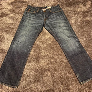 Blå jeans från Boss - Snygga blå jeans från Boss med regular fit. Klassisk design med fem fickor och orange sömmar. Nypris 1000kr, mitt pris 599kr. 