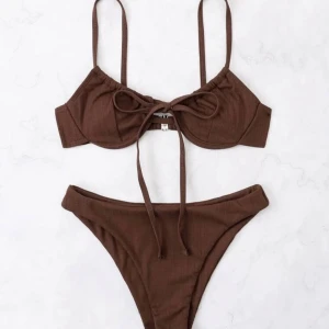 Brun ribbad bikini - Snygg brun bikini med ribbad textur och knytning fram. Toppen har justerbara axelband och en söt roset. Har aldrig använt då jag råkade beställa dubbelt. 