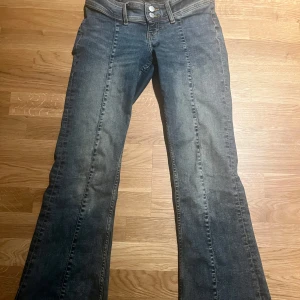 Lågmidjade bootcut jeans - Säljer ett par lågmidjade jeans med dubbla knappar från monki i storlek S utan några defekter💕