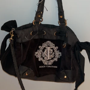 Vintage Juicy Couture väska  - Jättefin vintage juicy couture väska med rosett och hot pink/rosaröd insida! Ganska sliten i banden och innuti då den blivit använd mycket men annars i OK skick