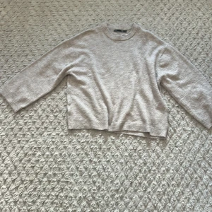 Beige stickad tröja från 157 - Säljer en mysig beige stickad tröja från 157. Tröjan har en rund halsringning, perfekt för kyligare dagar. Den är enkel och stilren, vilket gör den lätt att matcha med olika outfits.