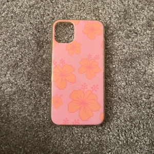 Rosa mobilskal med blommönster - Snyggt rosa mobilskal med stora orange blommor. Perfekt för att ge din telefon en somrig och färgglad look. IPHONE 11