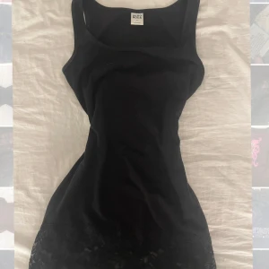 Vintage topp med spetsdetaljer  - Snygg lång svart toppfrån Vero Moda i storlek XS. Ärmlös och har en vacker spetsdetalj längst ner. Passar storlek XS och M med 😊📦