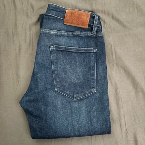 30W 34L Mörkblå jeans från Jack and Jones  - Säljer ett par klassiska mörkblå jeans från Jack and Jones. Jeansen har en enkel design och är tillverkade i ett mjukt denimtyg.