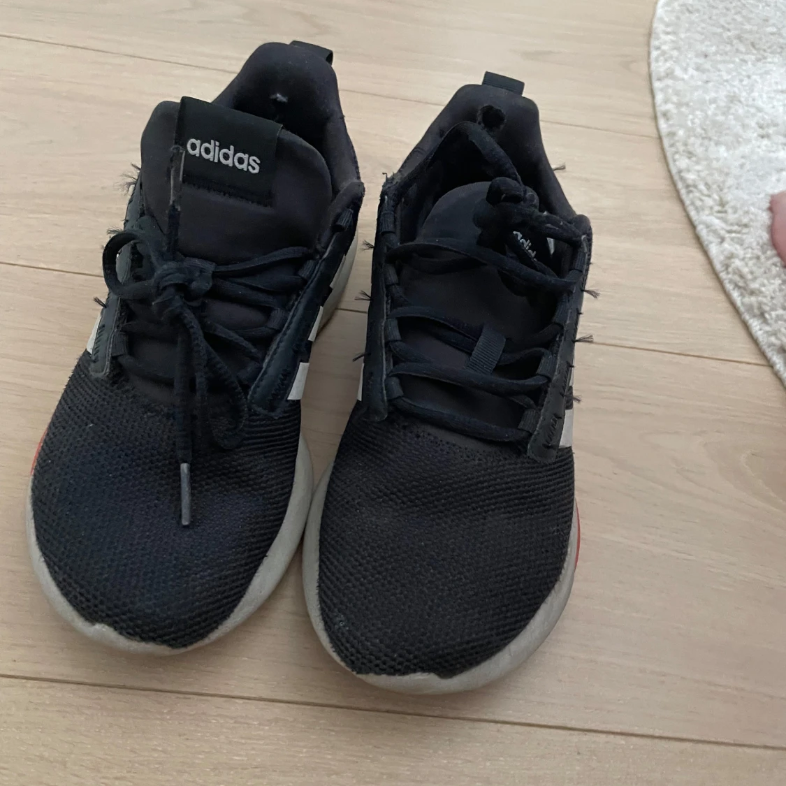 Svarta Adidas sneakers med vita ränder