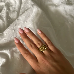 Edbladring - Cool och unik guldfärgad ring med markerade nitar i pyramidform. Ringen har en chunky design som sticker ut och passar perfekt för dig som vill ha ett statement-smycke. Snygg att bära ensam eller att matcha med andra ringar. Saknar 1 nit men de märks inte av