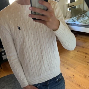Vit kabelstickad tröja från Polo Ralph Lauren - Säljer en klassisk vit kabelstickad tröja från Polo Ralph Lauren. Tröjan är i nytt skick och är använd fåtal gånger och jag säljer eftersom jag behöver pengar till annat