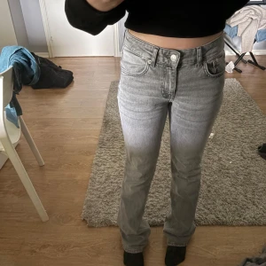 Grå jeans bootcut - Säljer ett par grå jeans med bootcut ben. Klassisk femficksmodell med normal passform och låg midja, skulle vela säga dock att de är mer åt mid hållet. Det är ganska tajta uppåt låren. Använt dom 1 gång.
