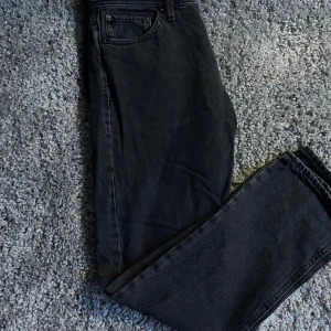 Svarta jeans från Jack & Jones Relaxed/Chris - Svarta jeans från Jack & Jones i modellen Relaxed/Chris. Klassisk femficksdesign med rak passform och normal midja. Jeansen har en enkel look utan slitningar och passar perfekt till vardags. Storleken är 30/30