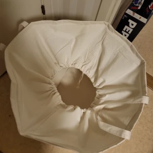 Vit tvättpåse med tryck - Stor vit tvättpåse i bomull med svarta handtag och texten 'Laundry Today or Naked Tomorrow' tryckt på framsidan. Påsen har dragsko upptill för enkel stängning och bärhandtag på sidorna.