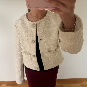 Vit tweed jacka från H&M - Säljer en vit tweed jacka från H&M i storlek XS. Jackan har rund halsringning, pärlknappar och två fickor framtill med pärldetaljer. Endast använd 1gång! Säker då den ej kommer till användning längre.                                                                             Priset är diskuterbart💕