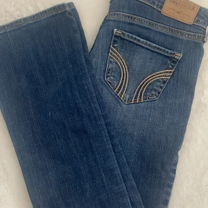 Blå jeans från Hollister - Snygga blåa jeans från hollister som är lågmidjade och bootcut. Jeansen är i storlek w25 Som är typ xs. Skriv privat för mer bilder på eller måtten💓💓. Priset kan diskuteras vid snabbt köp☺️💞