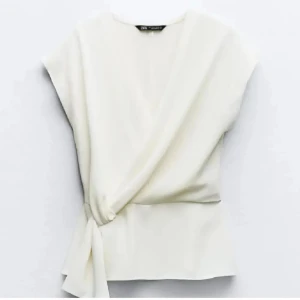 Vit omlottopp med knyt - Helt ny och oanvänd. Prislappen är kvar💕slutsålt på hemsidan. Nypris 329kr 