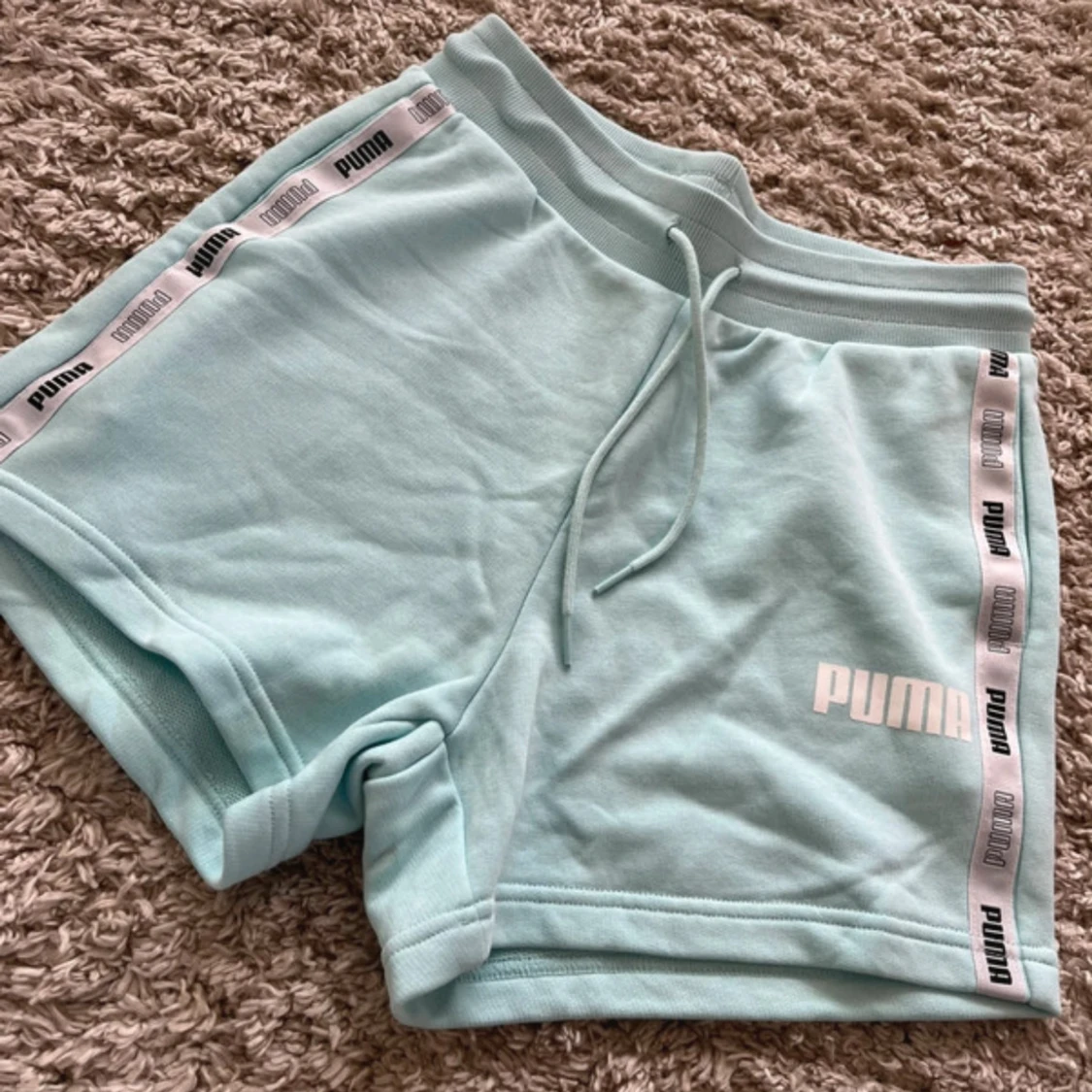 Ljusblå shorts från Puma med logoband