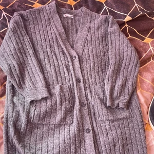 Grå ribbad kofta med fickor - Mysig grå kofta med ribbat mönster och stora framfickor. Koftan har knappar framtill och långa ärmar, från primark Spanien. 