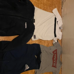 T-shirt olika märke allt för 250 - Klädpaket - Adidas, Nike, Levi’s - Strl S - Fint begagnat skick! Säljer ett klädpaket med fyra snygga originalplagg från populära märken. Alla i storlek S (herr/unisex) och i fint begagnat skick. Perfekt för vardag, fritid eller träning! Innehåll: 	•	Nike t-shirt – Vit med svart detalj och logga. Sportig och bekväm. 	•	Levi’s t-shirt – Grå med klassisk röd logga. Tidlös streetstil. 	•	Adidas tröja (mörkblå) – Dragkedja framtill, sportigt material. Passar både som lätt jacka eller mellanlager. 