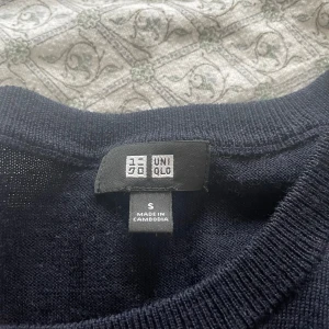 Mörkblå stickad tröja från Uniqlo - Säljer en enkel och stilren mörkblå stickad tröja från Uniqlo. Tröjan har rund halsringning och långa ärmar, perfekt för lager-på-lager eller som den är. Passar dig som gillar klassiska basplagg. Hör av dig vid minsta fundering!
