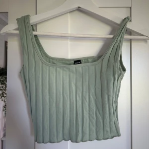 Ljusgrön ribbad linnetopp från SHEIN - Säljer en ljusgrön ribbad linnetopp från SHEIN. Toppen har breda axelband och en fyrkantig ringning. Perfekt för varma dagar och enkel att matcha med olika outfits.