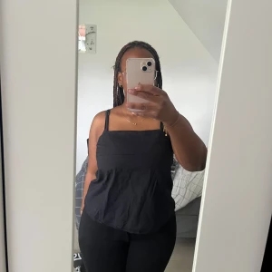 Svart A-linjeformad topp  - Svart a-linjeformad topp med bred, vikbar överkant och smal justerbara axelband med dold dragkedja bakifrån.                                                Endast använd ett få antal gånger.               Pris kan diskuteras.