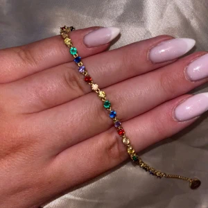 Färgglatt armband i guldfärg  - Guldigt armband med färgglada stenar i stål från Edblad, justerbar längd! Endast använd 1-2 gånger, som nu! 
